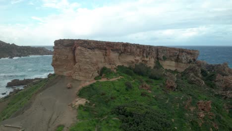 aerial: revealing plateu of il-qarraba rock and bay with mediterranean sea