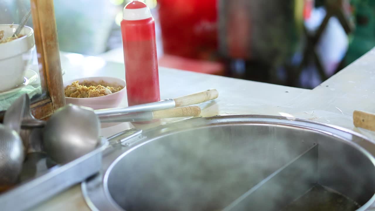 Zuppa di noodle fumante preparata al mercato di Bangkok
