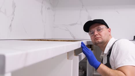 a professional employee checks the evenness of furniture installation installation accessories a professional employee checks the evenness of furniture installation installation of kitchen accessories