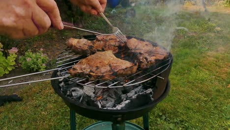 Chief using fork and turning the meat on the grill