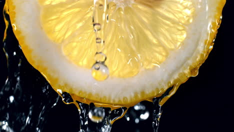 slice of lemon and water splashing on the black background in slow motion