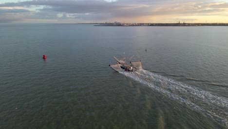 Trawler-vessel-moving-past-buoys-early-morning-traveling-to-fishing-spot