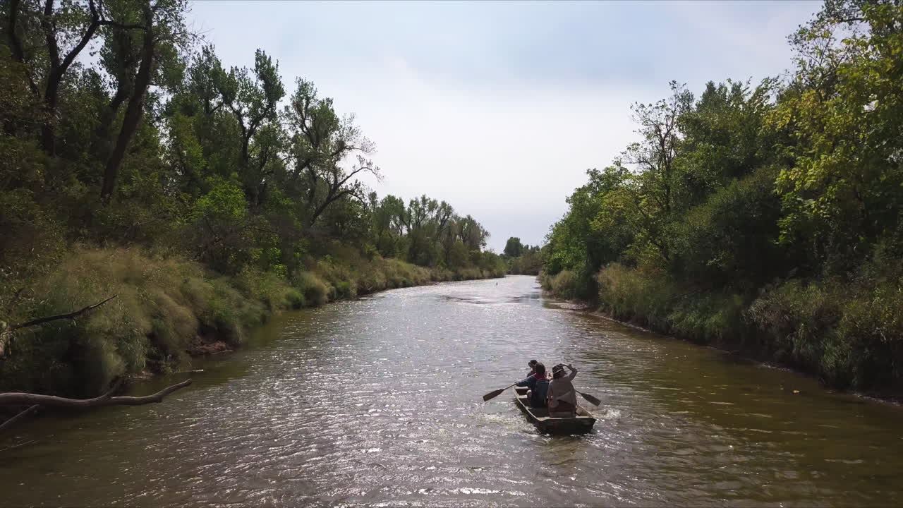 강을 노를 젓는 가족의 느린 공중 추적 샷