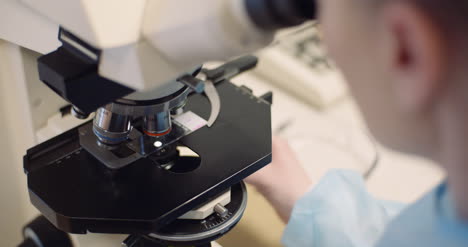 científico examinando bacterias bajo el microscopio en el laboratorio 3