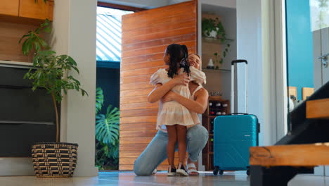 daughter greeting mother returning home with luggage from trip away