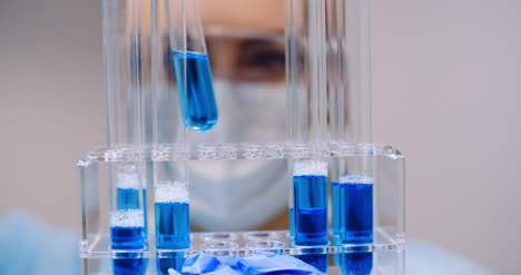 científica femenina sosteniendo tubos y matraz con líquido en las manos 10