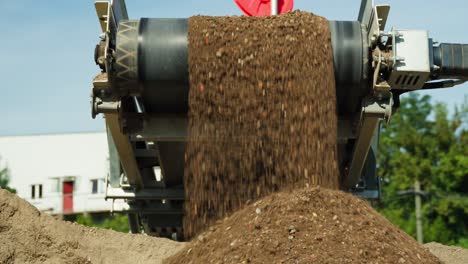 Sand-Gemischt-Mit-Kleinen-Steinen,-Die-Vom-Bandförderer-Im-Industriesteinbruch-Fallen---Herauszoomen