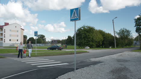 Family of three crossing the road