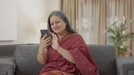 Happy-Indian-old-woman-scrolling-through-phone