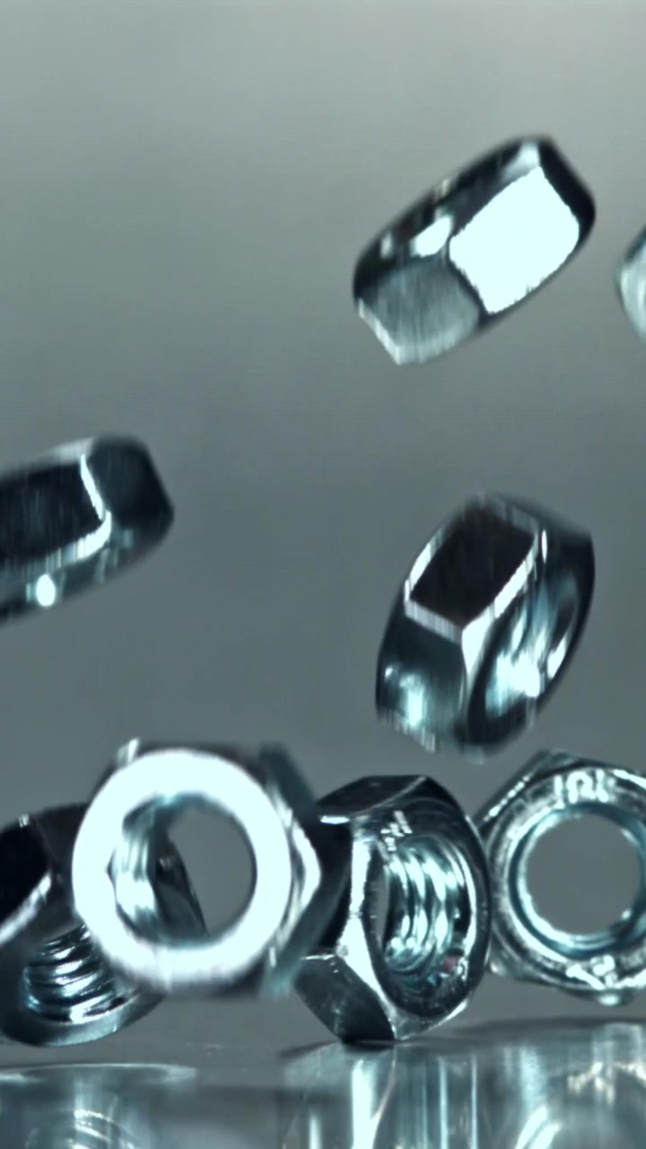 Metal Nuts Falling and Landing on a Reflective Surface in Slow Motion