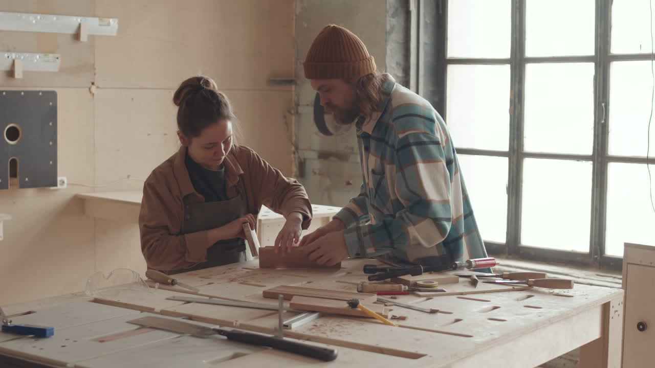 Professional Joiner Teaching Young Woman during Carpentry Course