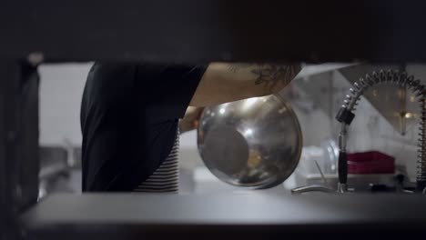 chef washing dishes in a restaurant kitchen