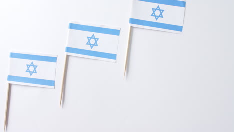close up of three flags of israel lying on white background with copy space