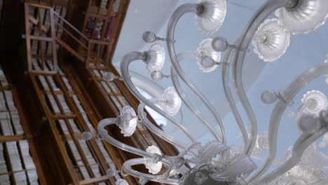 vertical - glass chandelier against wooden bookshelves in teresiana library in mantua, italy