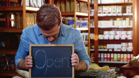 owner holding open signboard slate