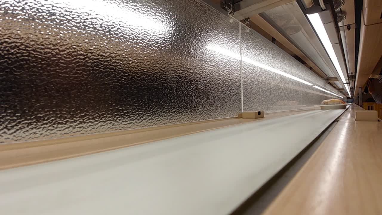 슈퍼 슬로우 모션으로 카메라를 향해 굴러가는 컨베이어 벨트 위의 니기리 스시