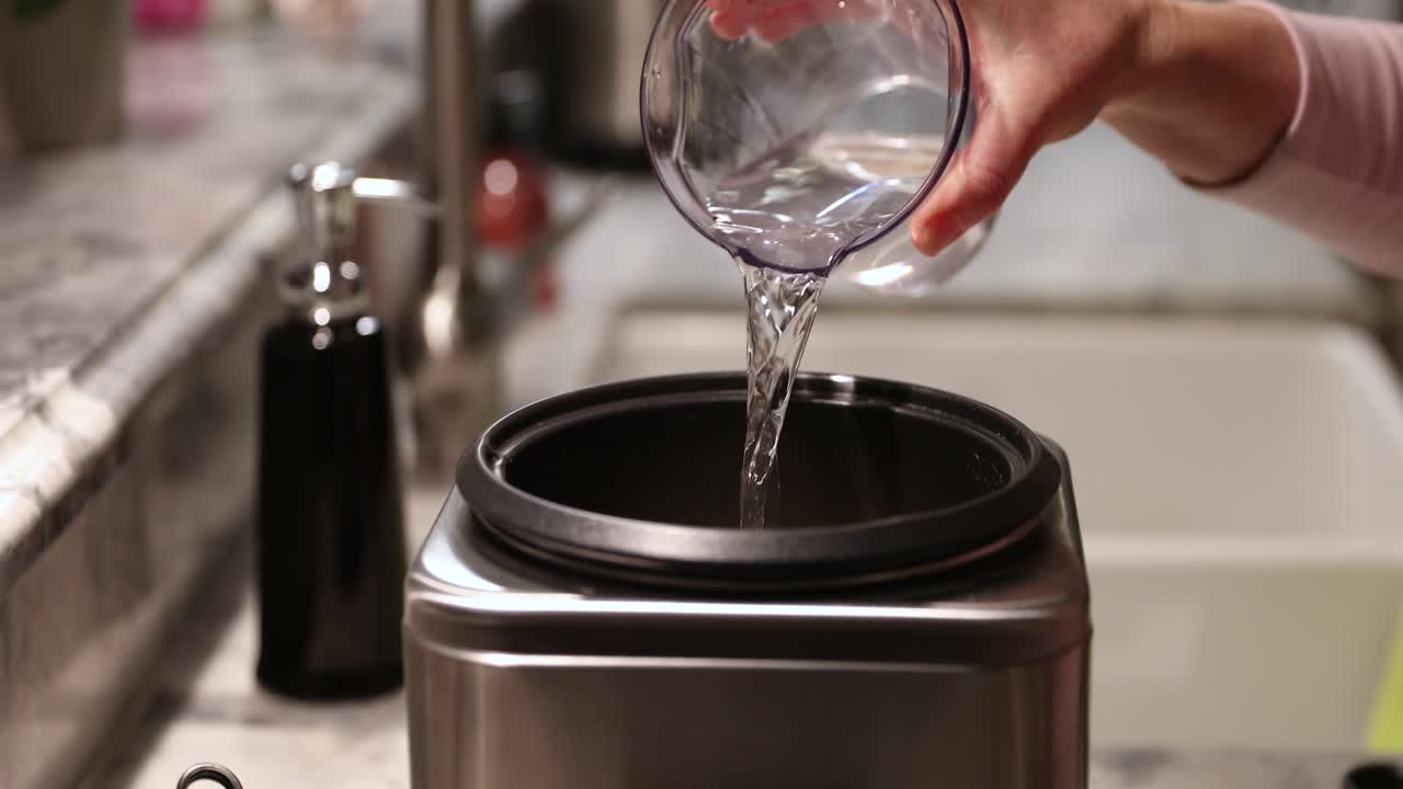 4k에서 밥솥에 물을 붓는 여자