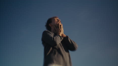 blurry person expressing emotion against a blue sky