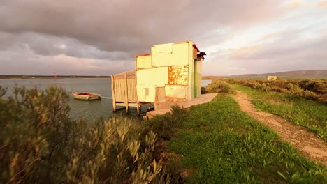 disparo de distanciamiento de casa construida improvisada con puerta verde, ubicada en las orillas del río, suburbios y viviendo cerca del concepto de agua del río