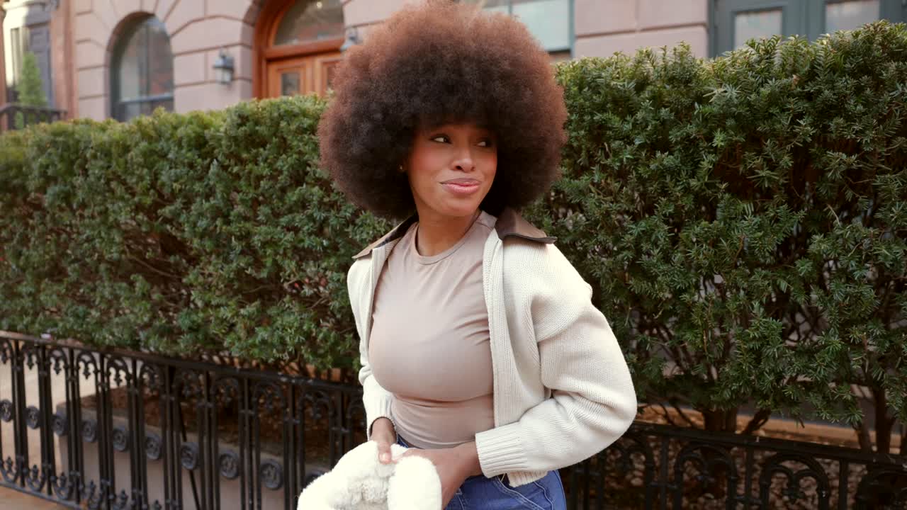 Donna con afro e paraorecchie in strada