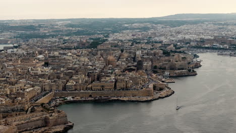 drone shot circling the skyline of valletta city, cloudy evening on malta island