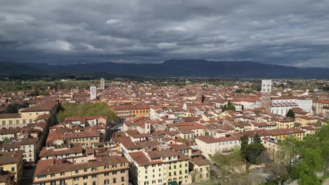lucca italy on sunny day with moody weather and mountains in the background
