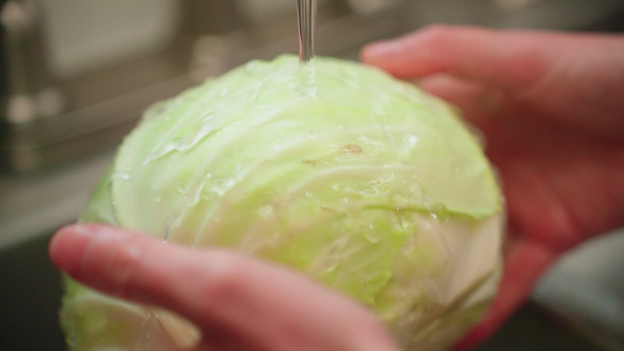 Washing head of cabbage in the sink by hand