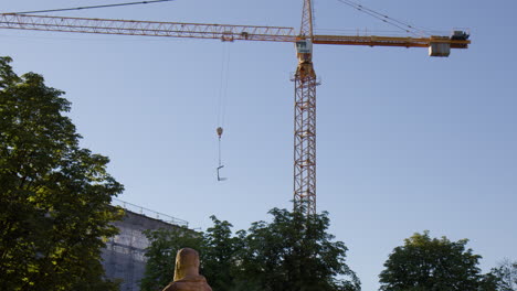 A-View-of-a-Construction-Crane-Against-a-Backdrop-of-Blue-Sky-in-Baden-Baden,-Germany---Low-Angle-Shot