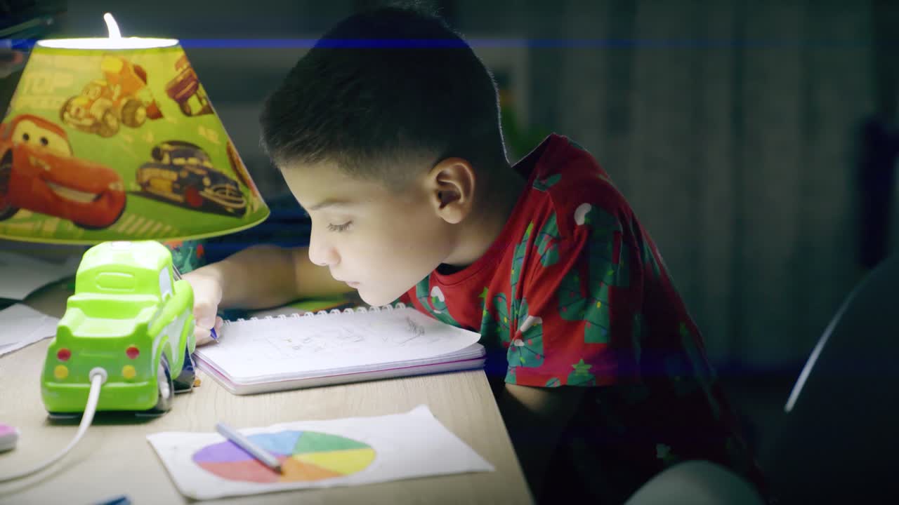 피곤 한 아이 는 밤 에 숙제 를 하고 책상 에서 자고 있다