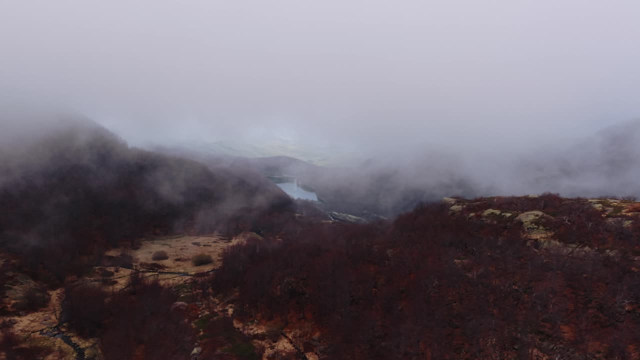 Misty aerial view of the Dolomites Mountains in Italy with dense fog surrounding the landscape