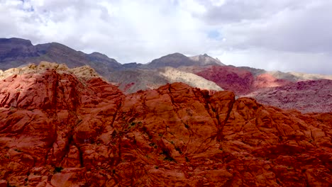 aerial drone shot rising up above the red rock canyon mountains during the daytime in las vegas nevada