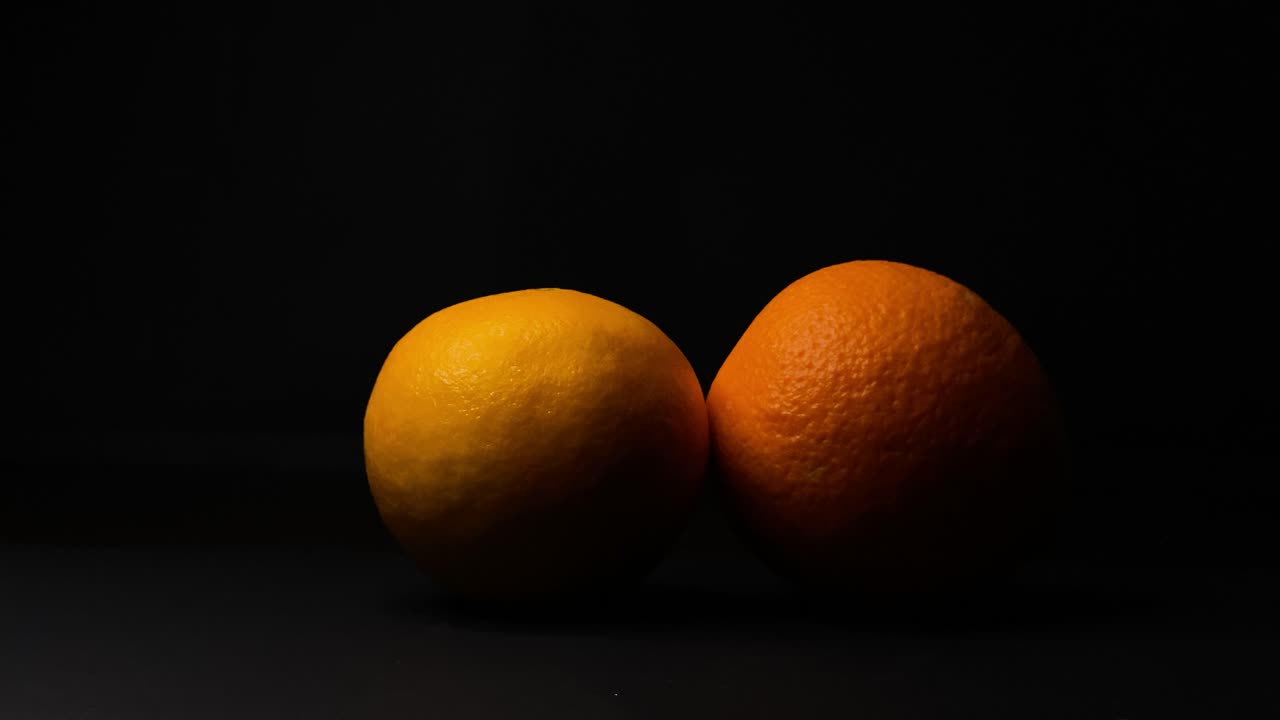 toma estática de la mano de la mujer recoge fruta naranja, fondo negro