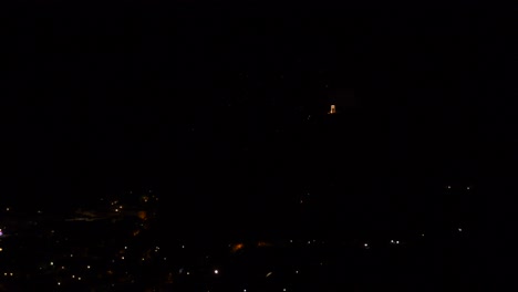 celebración con coloridos y brillantes fuegos artificiales, sobre un pueblo de montaña, por la noche
