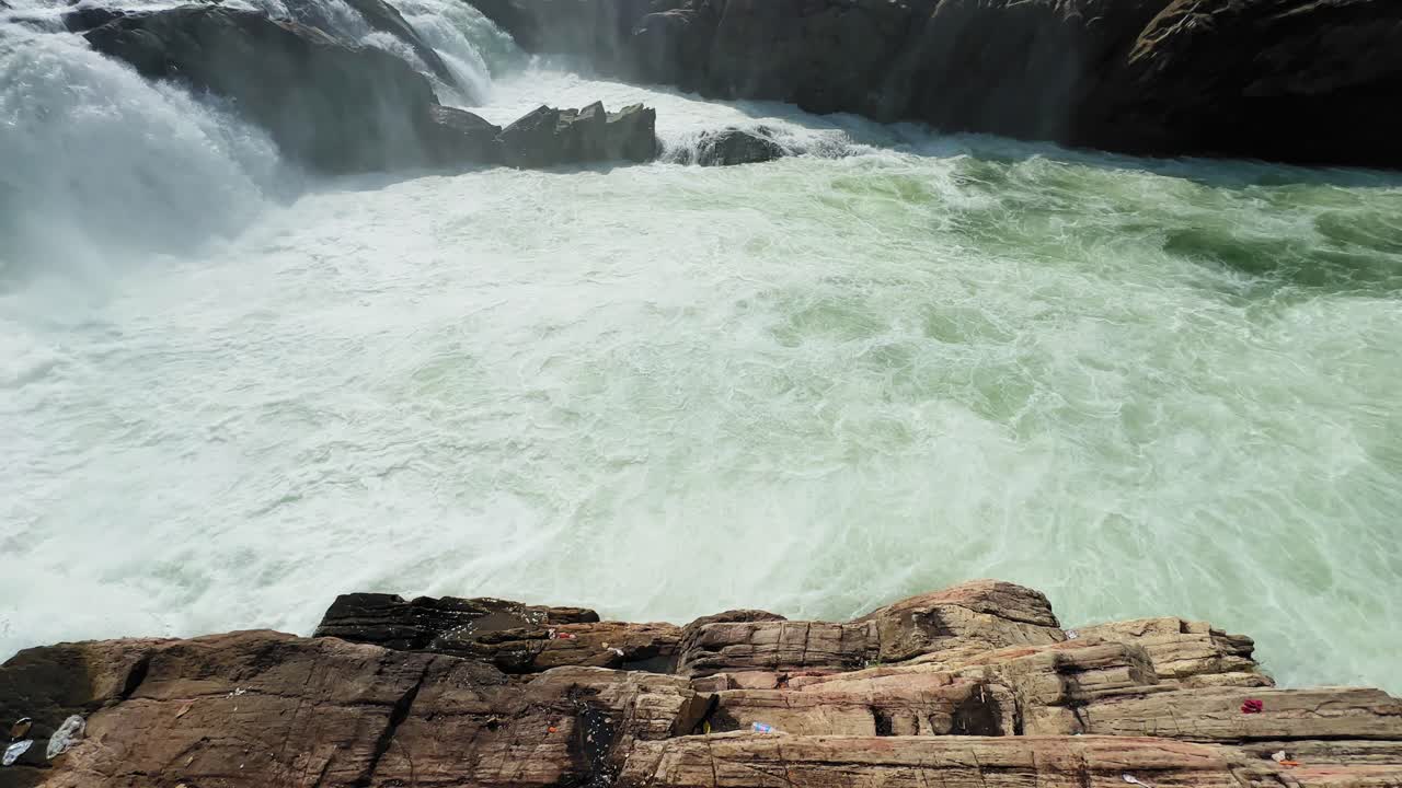 Static shot of Dhuandhar Waterfall at Bhedaghat, Jabalpur, as the Narmada River crashes into a foaming plunge pool, creating intense white water, turbulence and natural force
