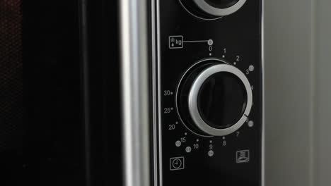 Setting-microwave-timer-to-seven-minutes-and-turning-microwave-off---close-angled-shot