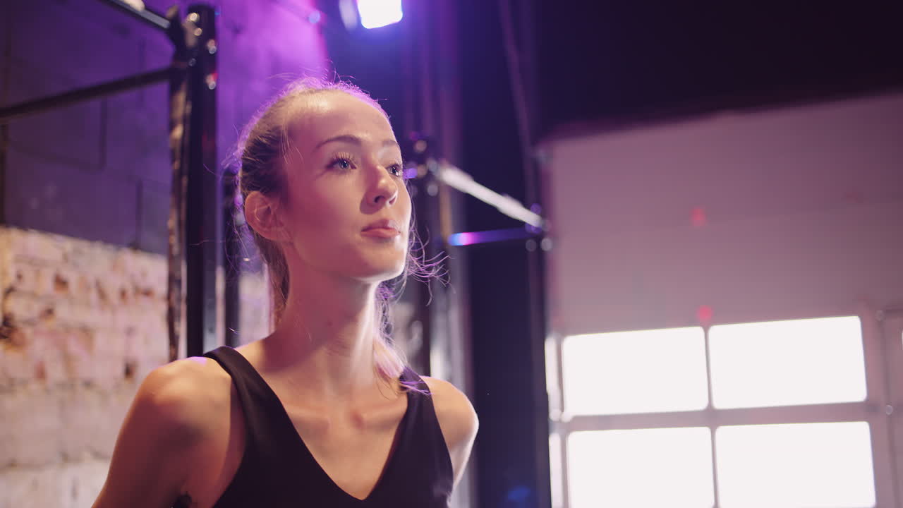 Atleta donna attraente e sicura di sé che guarda altrove mentre si trova in un centro fitness.