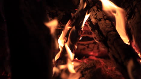 Panning-motion-shot-of-logs-burning-in-a-fire-pit