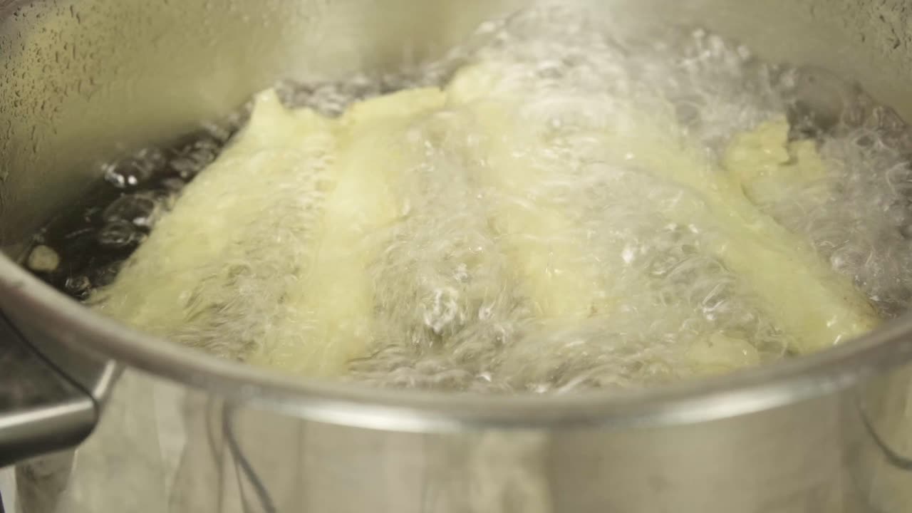 Primo piano di cavolfiori bianchi che bollono in una pentola d'acqua.