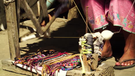 Old-lady-weaving-traditional-cloth-called-sarong-in-Sade-village---feet-level-shot