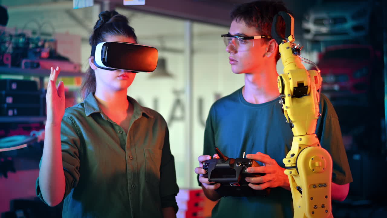 Teens doing experiments in robotics in a laboratory. Boy in protective glasses and girl in VR headset controlling the robot using controller and hand. Red and blue illumination. Slow motion