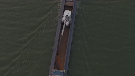 close up shot of cargo ship full of sand on ijsselmeer during sunset, aerial