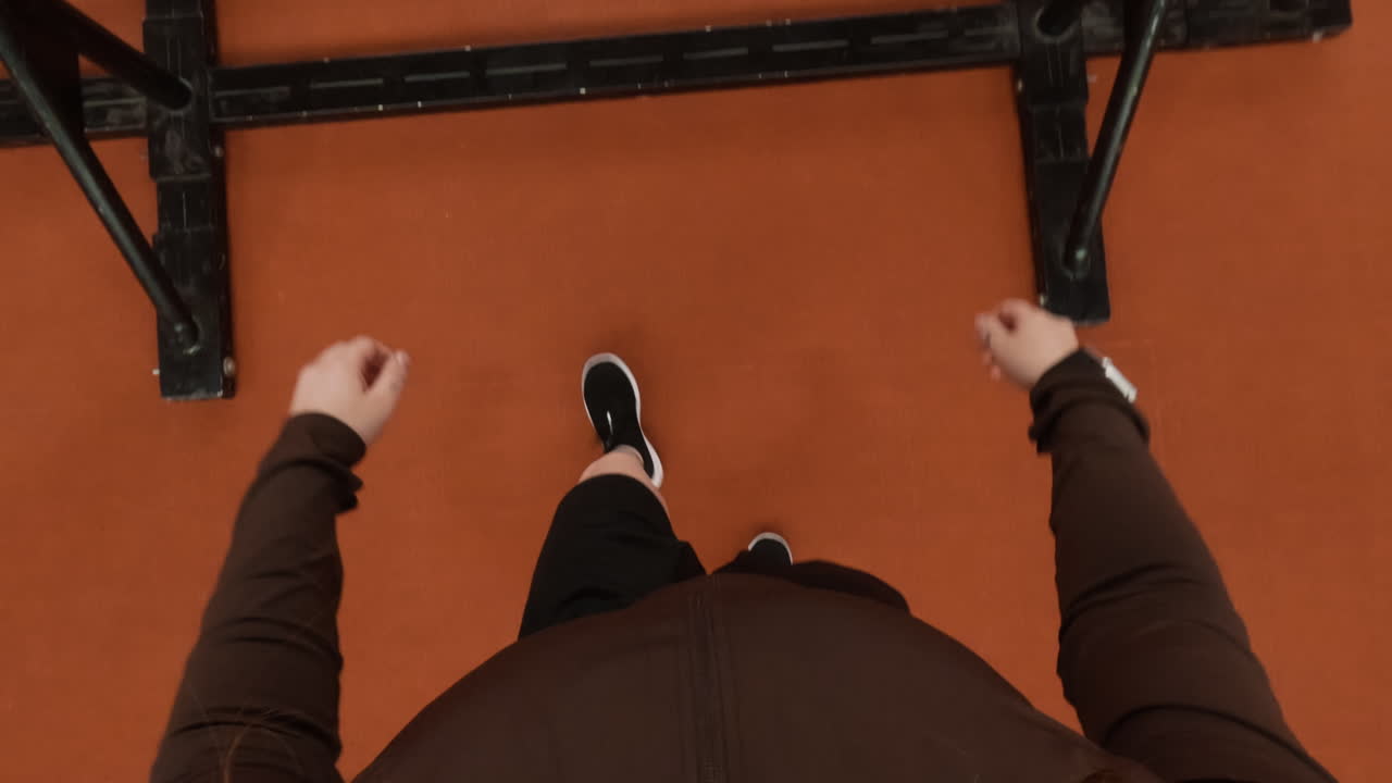 First-person perspective looking down at feet and torso on an orange floor
