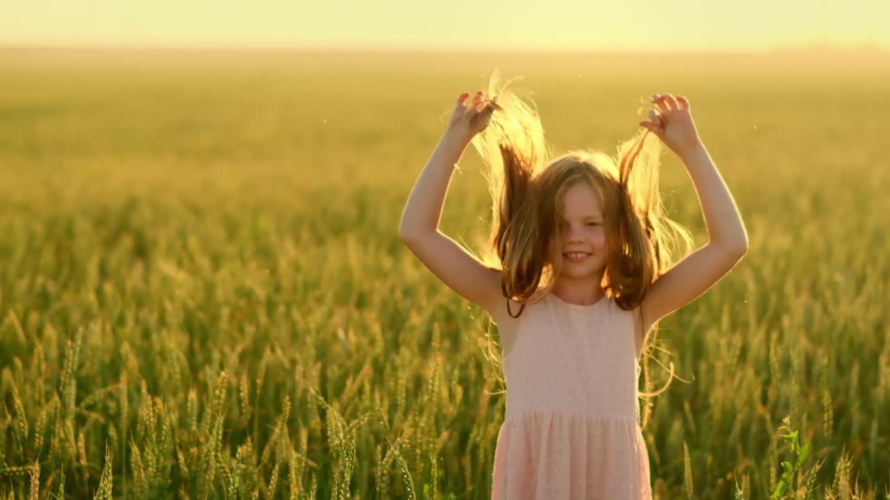 Girl playing in a wheat field at sunset