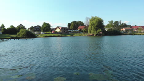 Drohne-Fliegt-über-Dem-Wasser-Am-Podpeč-See-In-Slowenien,-Mit-Sommergrüner-Natur-Und-Seerosen