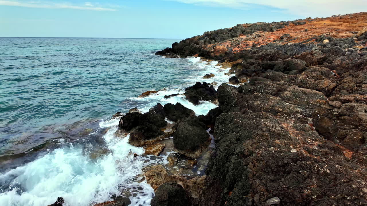 Rocky coast coastline volcanic rock Crete island Greece, waves breaking shoreline
