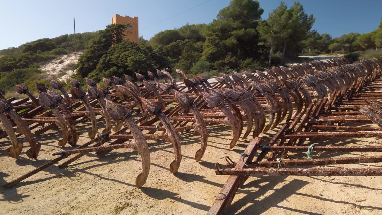 Pan Right of Rusty Anchors Lined Up in Rows Used for Tuna Fishing Nets