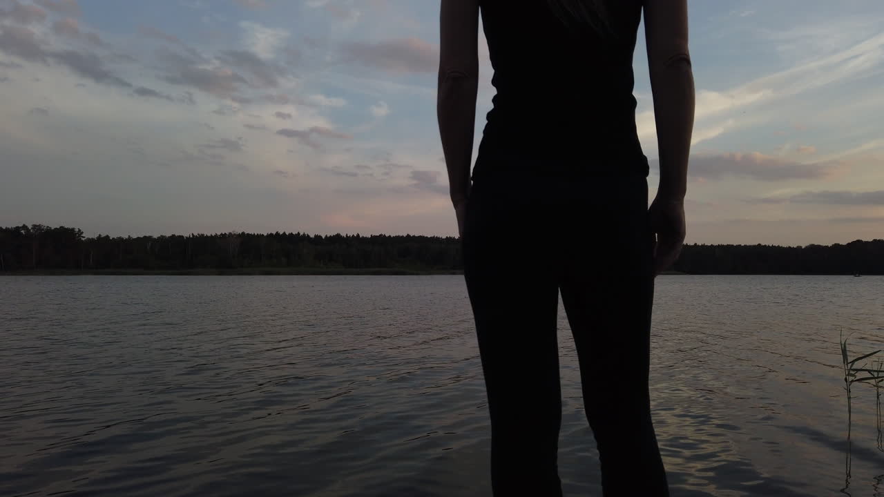 mujer en un pequeño muelle admira el maravilloso lago al atardecer