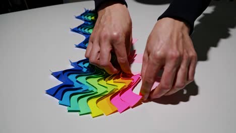 colorful paper arrangement with hands