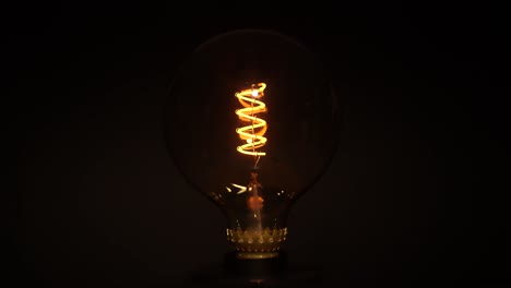 light bulb flickering over dark black background