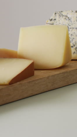 video of assorted hard and soft cheeses on wooden chopping board